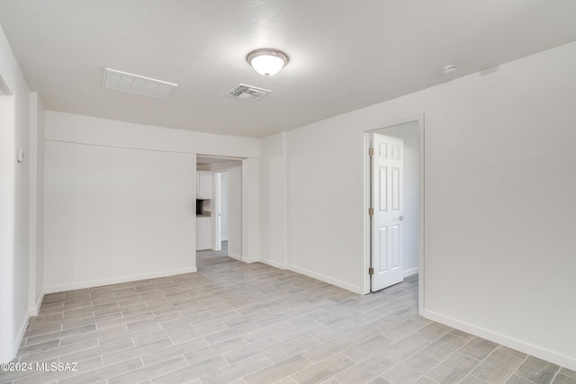 empty room featuring visible vents, baseboards, and light wood-style flooring