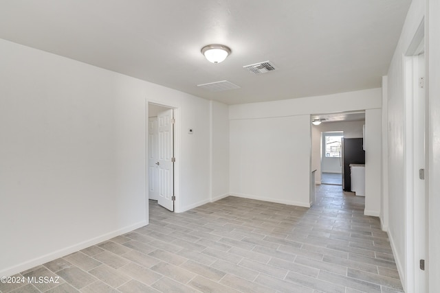 empty room featuring baseboards and visible vents