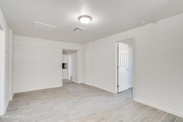 unfurnished room featuring light wood finished floors, baseboards, and visible vents