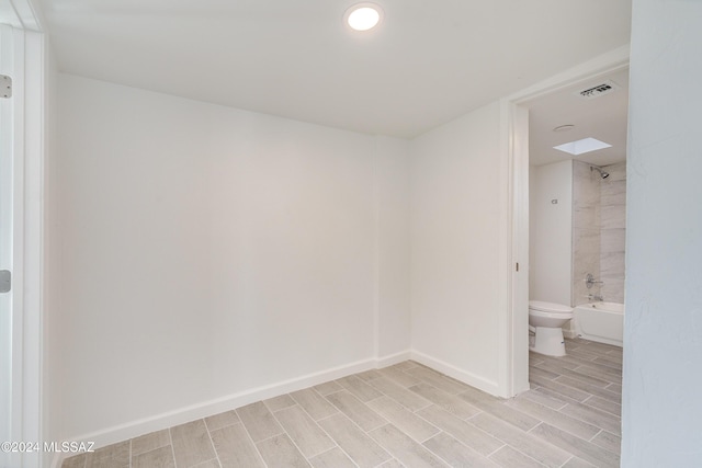 unfurnished room with wood finish floors, baseboards, and visible vents