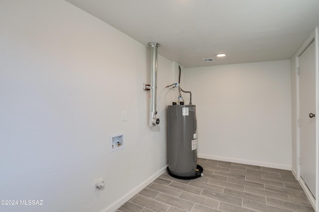 interior space with electric water heater and visible vents