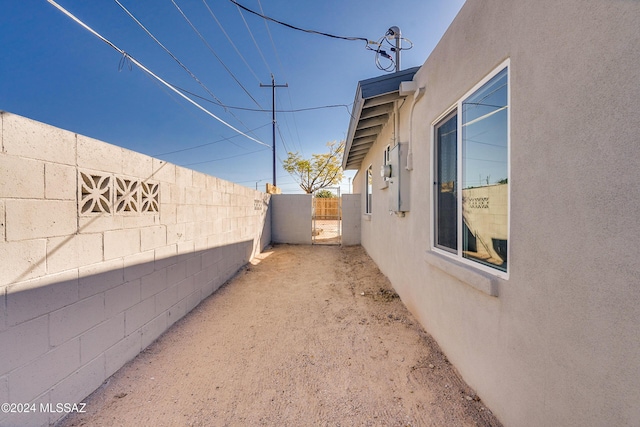 view of side of home with fence and stucco siding