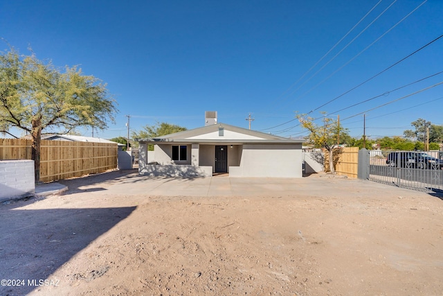 view of front facade with fence and stucco siding