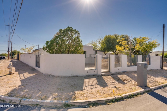 view of front of home featuring concrete block siding, a gate, and a fenced front yard