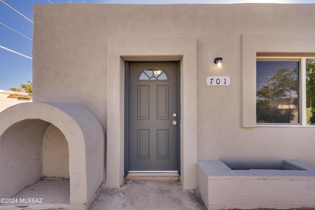 doorway to property featuring stucco siding