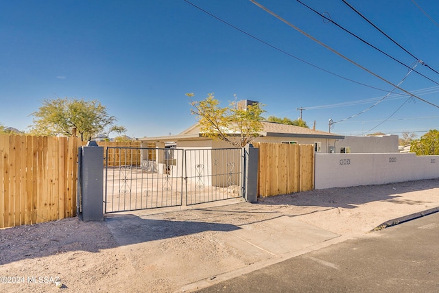 view of gate with a fenced front yard