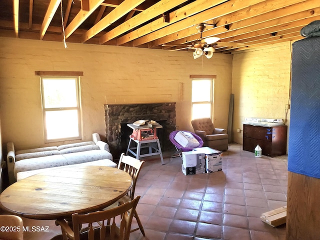 dining room with ceiling fan, plenty of natural light, and beamed ceiling
