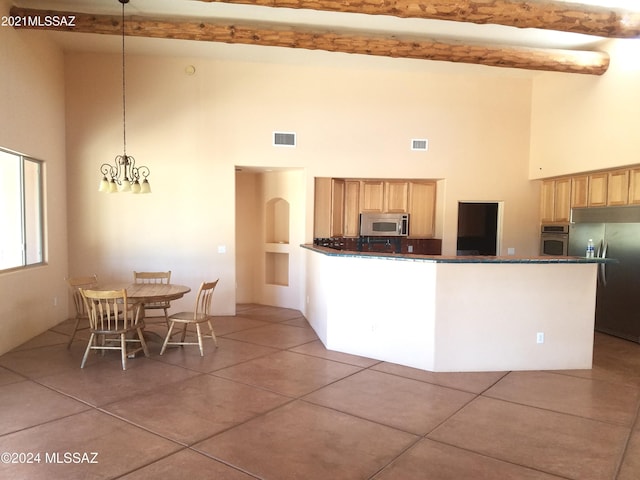 kitchen featuring appliances with stainless steel finishes, tile patterned floors, a high ceiling, and pendant lighting