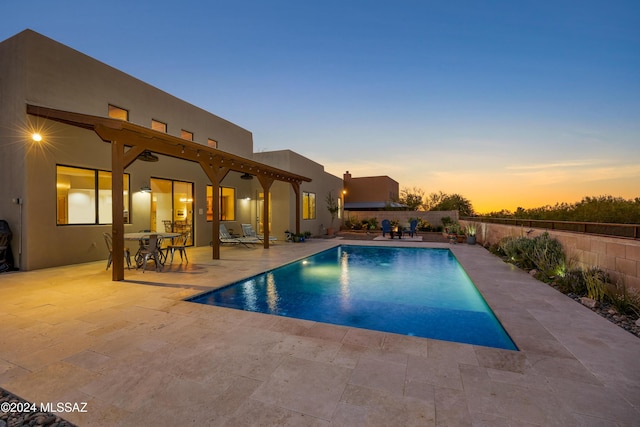 pool at dusk with a patio area