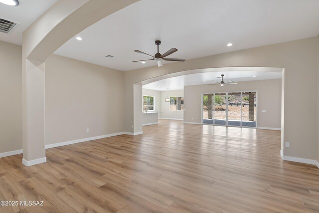 67620 E Lauren Pl, Oracle, AZ 85623 - unfurnished living room featuring a ceiling fan, light wood-style flooring, arched walkways, recessed lighting, and baseboards