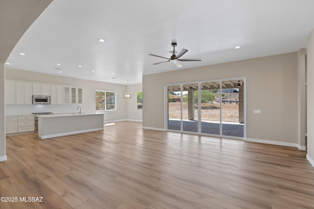67620 E Lauren Pl, Oracle, AZ 85623 - unfurnished living room featuring plenty of natural light, a ceiling fan, light wood-style flooring, recessed lighting, and baseboards