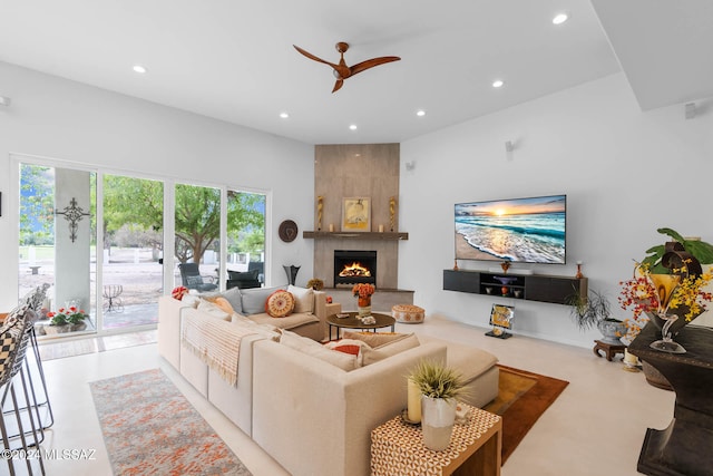 living room with a large fireplace and ceiling fan