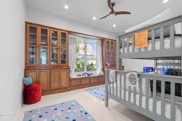 bedroom featuring ceiling fan and a nursery area