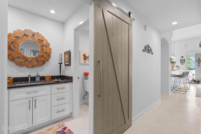 bathroom featuring concrete flooring, vanity, and toilet