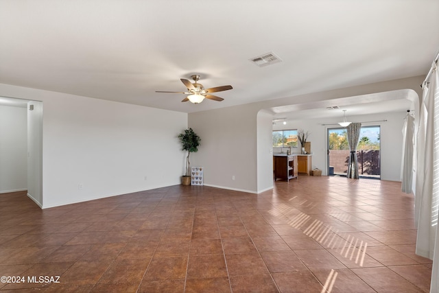 spare room featuring dark tile patterned flooring and ceiling fan