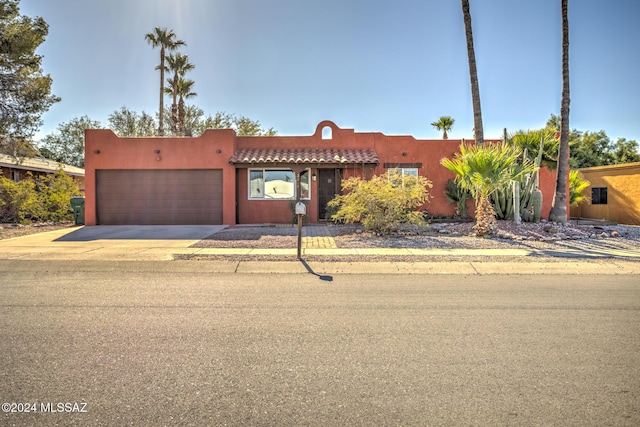 pueblo revival-style home featuring a garage