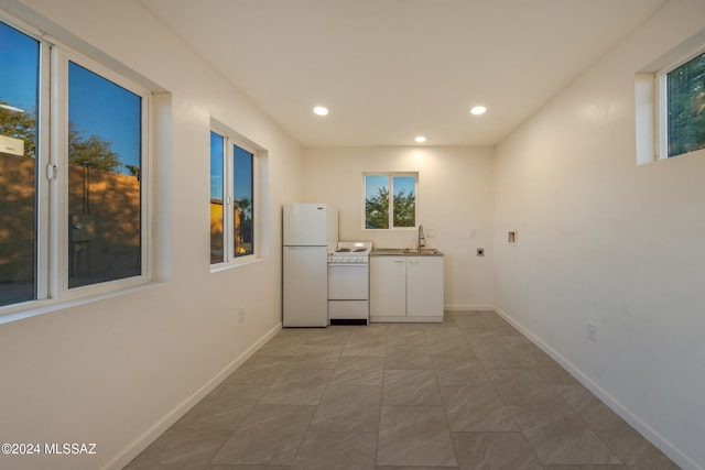 kitchen with white cabinets, white appliances, and sink