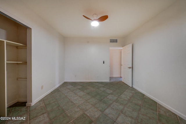 unfurnished bedroom with ceiling fan and a closet