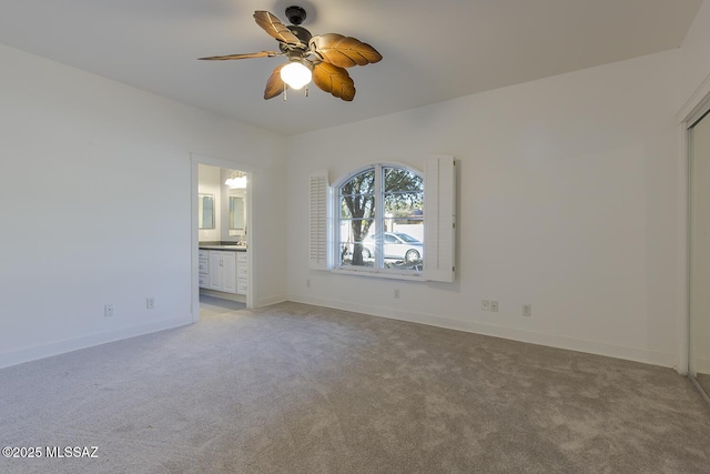 spare room with light colored carpet, baseboards, and ceiling fan