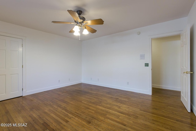 spare room with a ceiling fan, dark wood-style floors, and baseboards