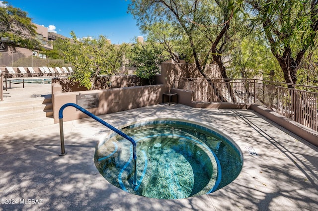 view of swimming pool with a hot tub