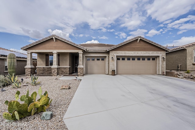 view of front of property featuring stone siding, an attached garage, stucco siding, a tile roof, and driveway