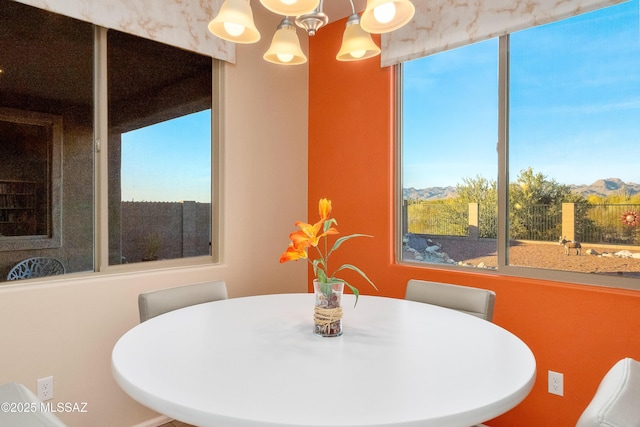 dining room with an inviting chandelier, plenty of natural light, and a mountain view