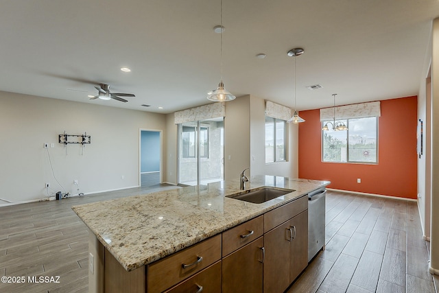 kitchen with a sink, dishwasher, open floor plan, wood finish floors, and visible vents