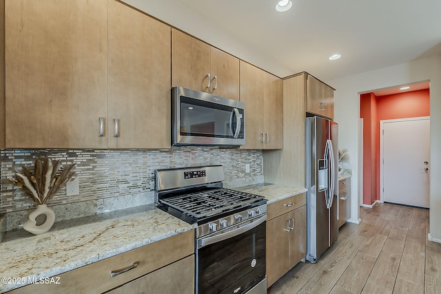 kitchen featuring backsplash, light stone countertops, light wood-type flooring, stainless steel appliances, and recessed lighting