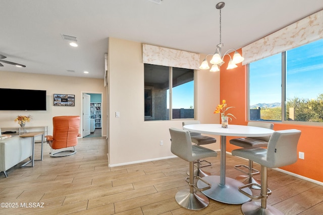 dining space featuring wood tiled floor, visible vents, a notable chandelier, and baseboards