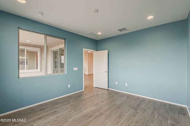 spare room with baseboards, visible vents, recessed lighting, and wood finished floors