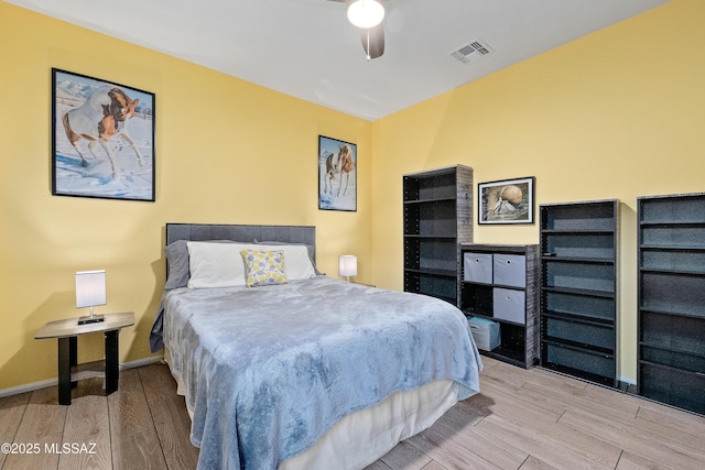 bedroom featuring light wood-type flooring, visible vents, ceiling fan, and baseboards