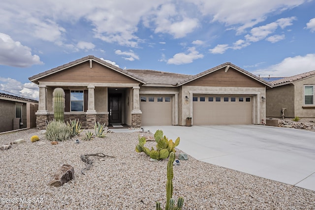 view of front of property with stone siding, concrete driveway, stucco siding, an attached garage, and a tiled roof