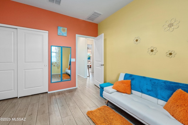 living room featuring baseboards, visible vents, and wood tiled floor