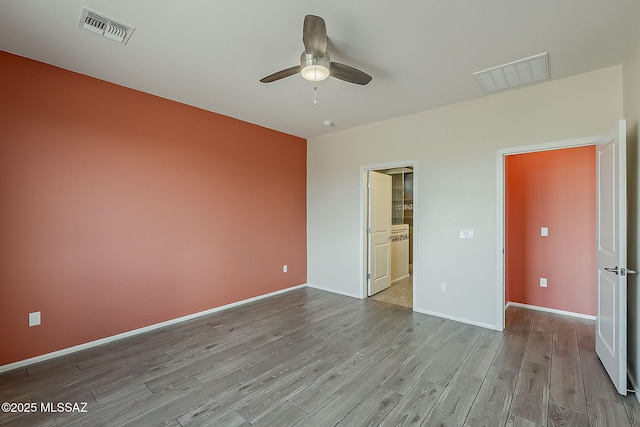 unfurnished bedroom featuring baseboards, ceiling fan, visible vents, and wood finished floors