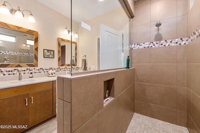 full bath with vanity, decorative backsplash, and a walk in shower