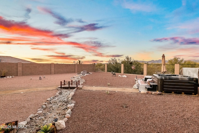 view of yard with a fenced backyard and a hot tub