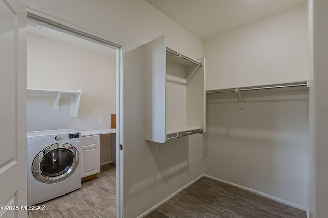 laundry area with light wood-style flooring, washer / clothes dryer, cabinet space, and baseboards