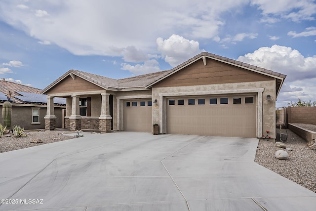 view of front facade featuring driveway, stone siding, stucco siding, fence, and an attached garage