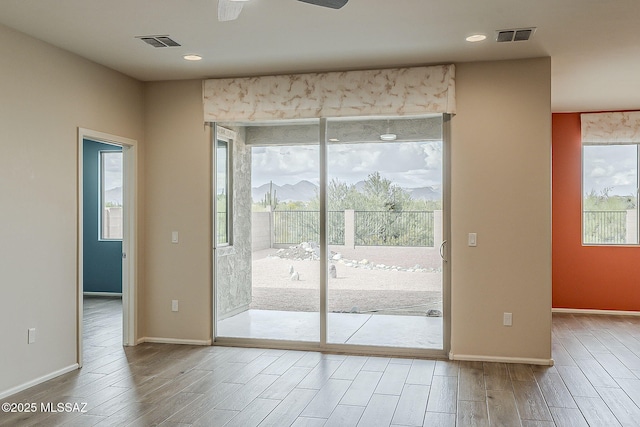 interior space with baseboards, visible vents, and wood finished floors