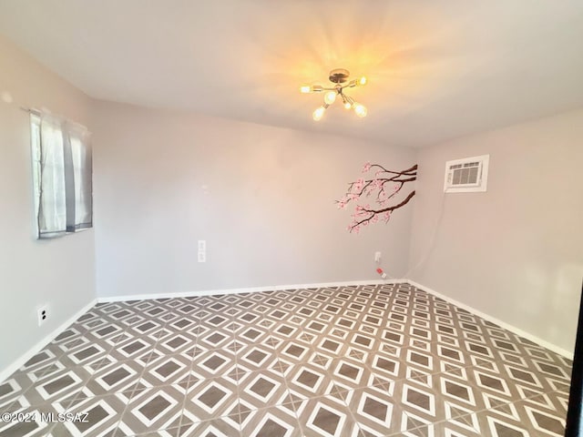 unfurnished room featuring a wall unit AC and an inviting chandelier