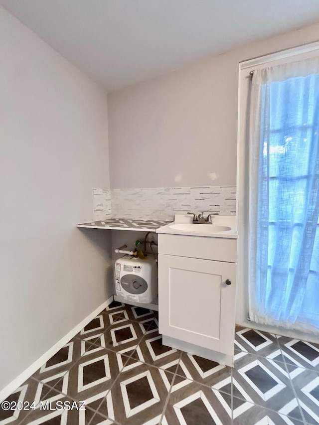 laundry room with dark tile patterned flooring and sink