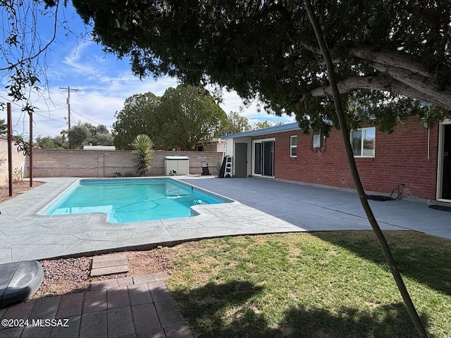 view of swimming pool featuring a lawn and a patio area