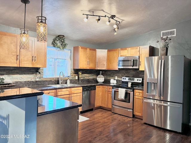 kitchen featuring backsplash, dark wood-type flooring, sink, decorative light fixtures, and stainless steel appliances