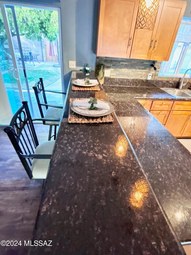 interior space featuring backsplash, a wealth of natural light, sink, and light brown cabinetry