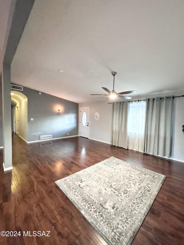 unfurnished living room with ceiling fan and dark wood-type flooring