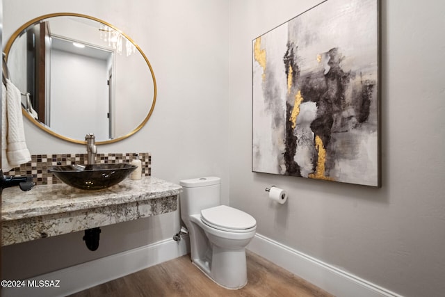 bathroom with hardwood / wood-style flooring, toilet, and sink