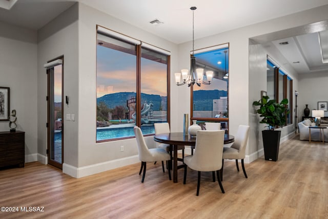 dining space with a chandelier, a mountain view, and light hardwood / wood-style floors