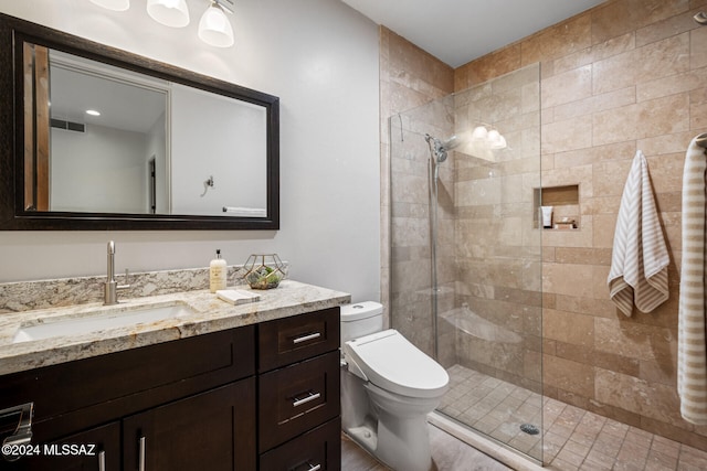 bathroom featuring vanity, toilet, and an enclosed shower