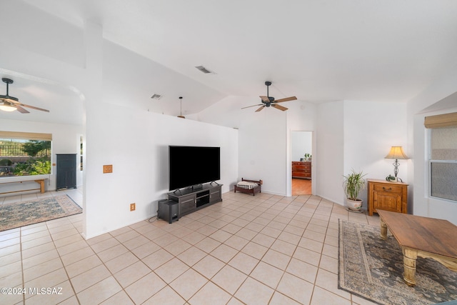 living room featuring ceiling fan, lofted ceiling, and light tile patterned flooring